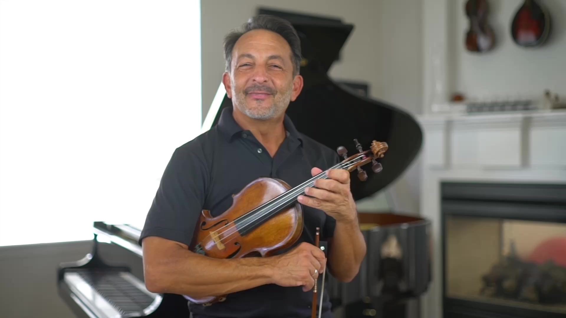 Richard Amoroso speaking with his violin in the studio